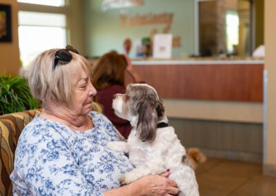 Senior woman holding dog at veterinarian