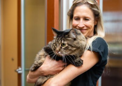 Smiling woman with Maine Coon cat.